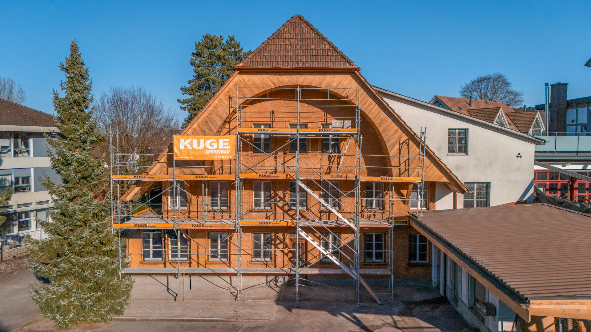 Gerüst mit Treppenaufgang an einem historischen Holzbau – Foto: KUGE Bau AG